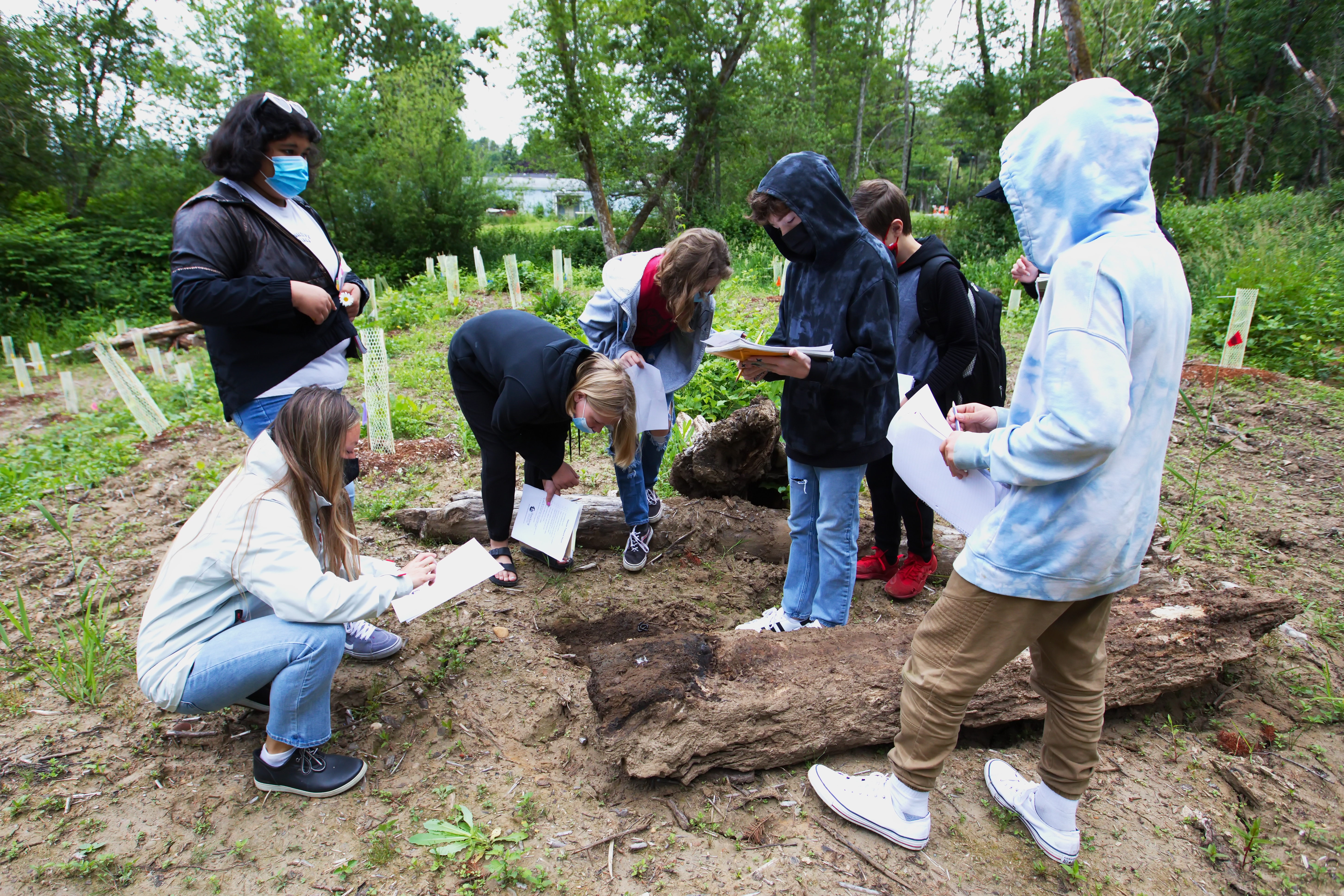 Students on a nature hike look for bugs and wildlife